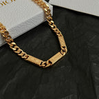 Gold chain bracelet-style necklace with engraved rectangular logo tag