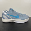Light blue and gray basketball shoes with white sole, blue swoosh, lace-up.