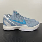 Light blue and gray basketball shoes with white sole, blue swoosh, lace-up.