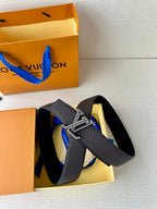 Louis Vuitton belt in dark leather with prominent gold-tone chain buckle
