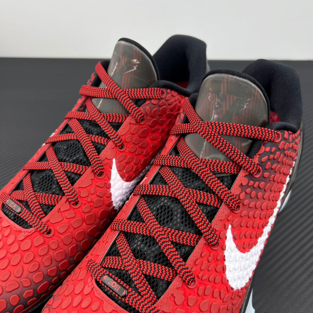 Red basketball shoes with black laces and textured upper with white swoosh panel.