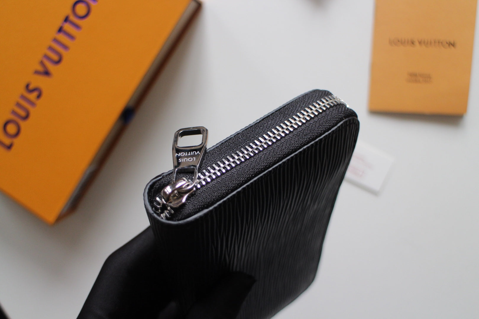 Dark textured leather zip wallet with metal zipper pull and front ring