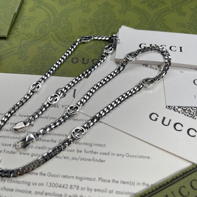 Silver-tone chain necklace with round pendant, layered links, and clasp rings