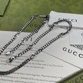 Silver-tone chain necklace with round pendant, layered links, and clasp rings