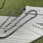 Silver-tone chain necklace with round pendant, layered links, and clasp rings