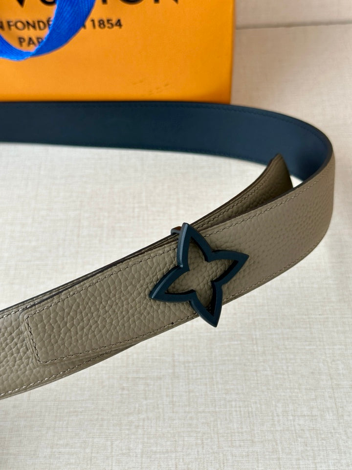 Louis Vuitton belt close-up: light gray strap with dark star buckle and blue accents