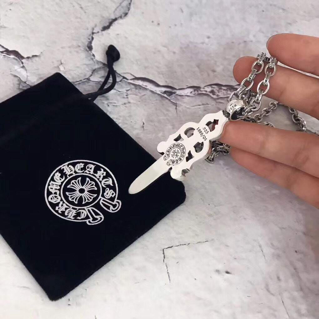 Chrome accessories dagger pendant necklace with silver chain, close view in hand