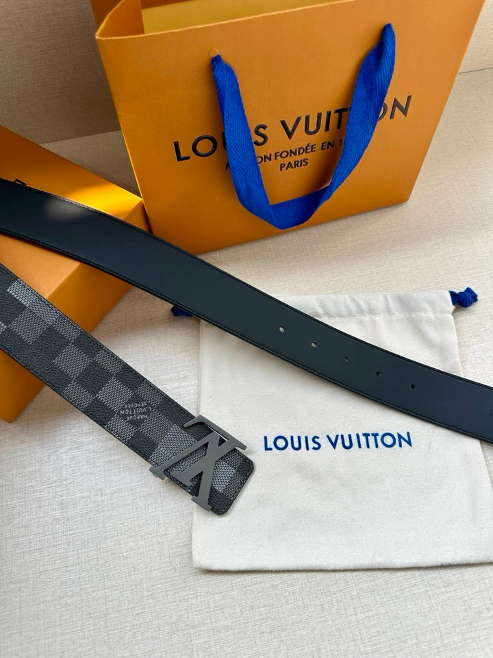 Designer belt with gray and dark Damier pattern and LV buckle, flat lay