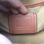 Coah bag interior label close-up with stamped text and stitched edge