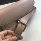 Coah bag strap close-up with adjustable buckle and stitched trim