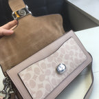 Coah bag front close-up with taupe flap, logo panel, and silver snap