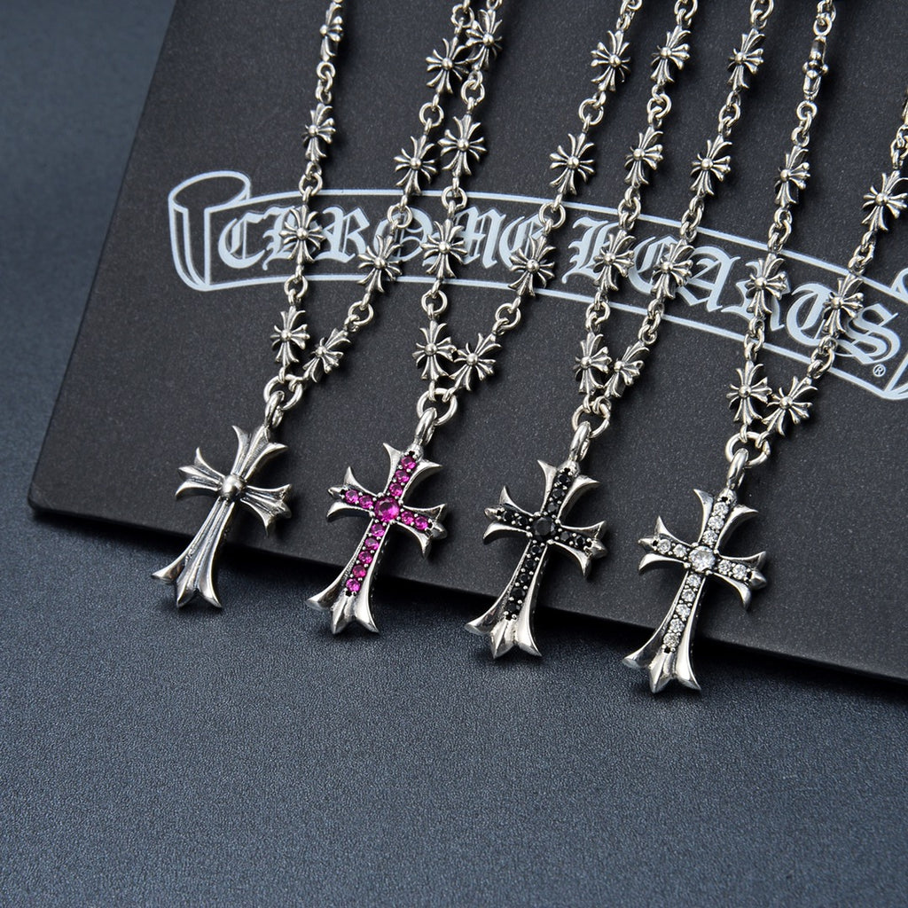 Silver-tone cross pendant necklace with floral charms and purple gem accents