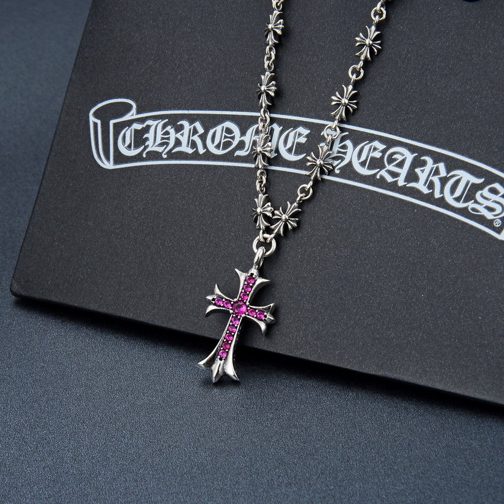 Silver-tone cross pendant necklace with purple gem and flower charm accents