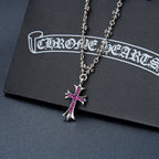 Silver-tone cross pendant necklace with purple gem and flower charm accents