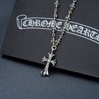 Silver-tone cross pendant necklace with flower charms and purple gem cross