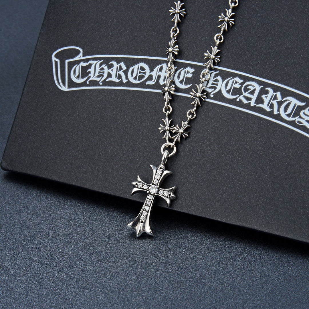 Silver-tone cross pendant necklace with flower charms and purple gem cross
