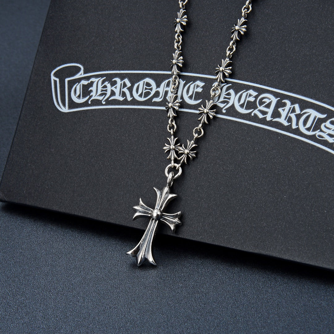 Silver-tone cross pendant necklace with small flower charms on a chain