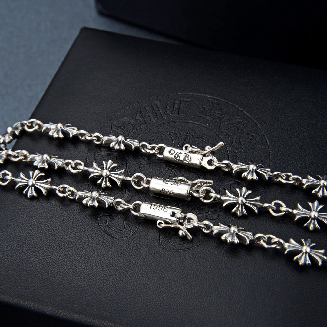 Silver-tone charm necklace with floral links and small clasp detail
