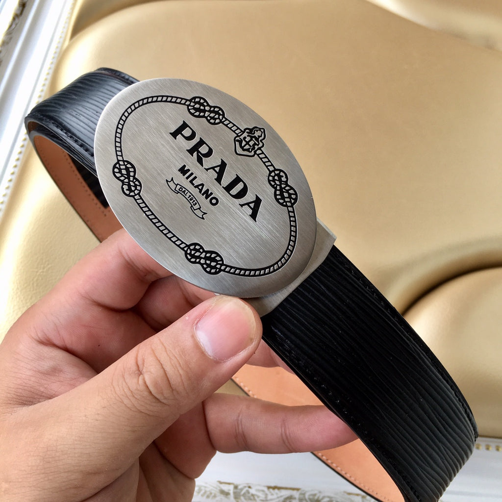 Prada belt close-up of oval Prada Milano logo label on black ribbed strap