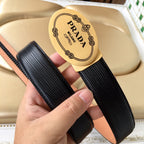 Prada belt view: black textured strap and tan leather side with gold oval Prada Milano buckle.