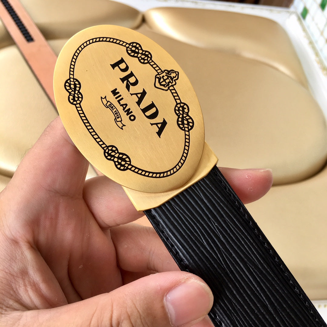 Prada belt logo plate close-up on black textured strap with tan strap edge.