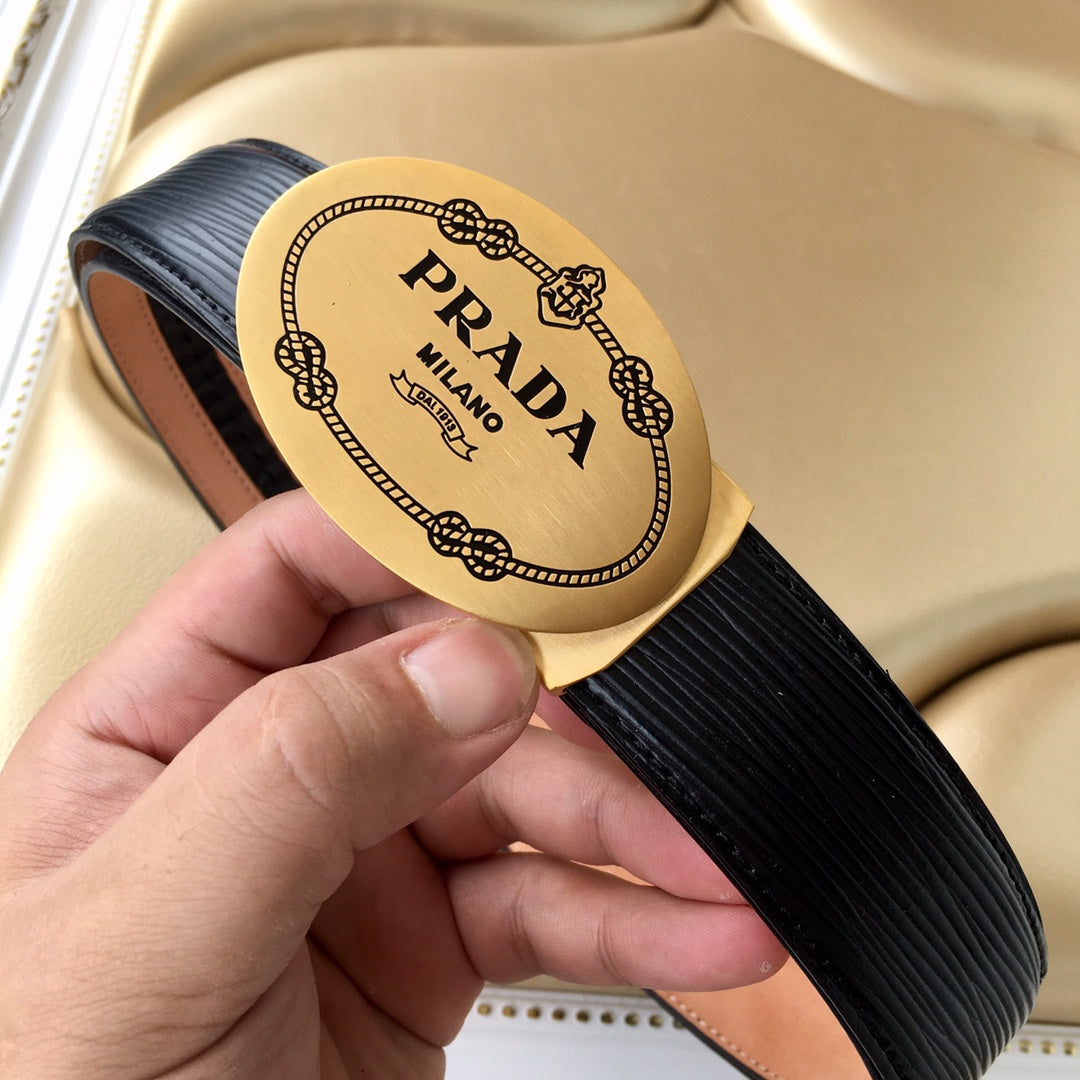 Prada belt buckle close-up on black ribbed strap with tan trim, held in hand.