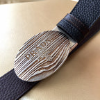 Prada belt oval silver logo buckle with engraved text on dark textured leather