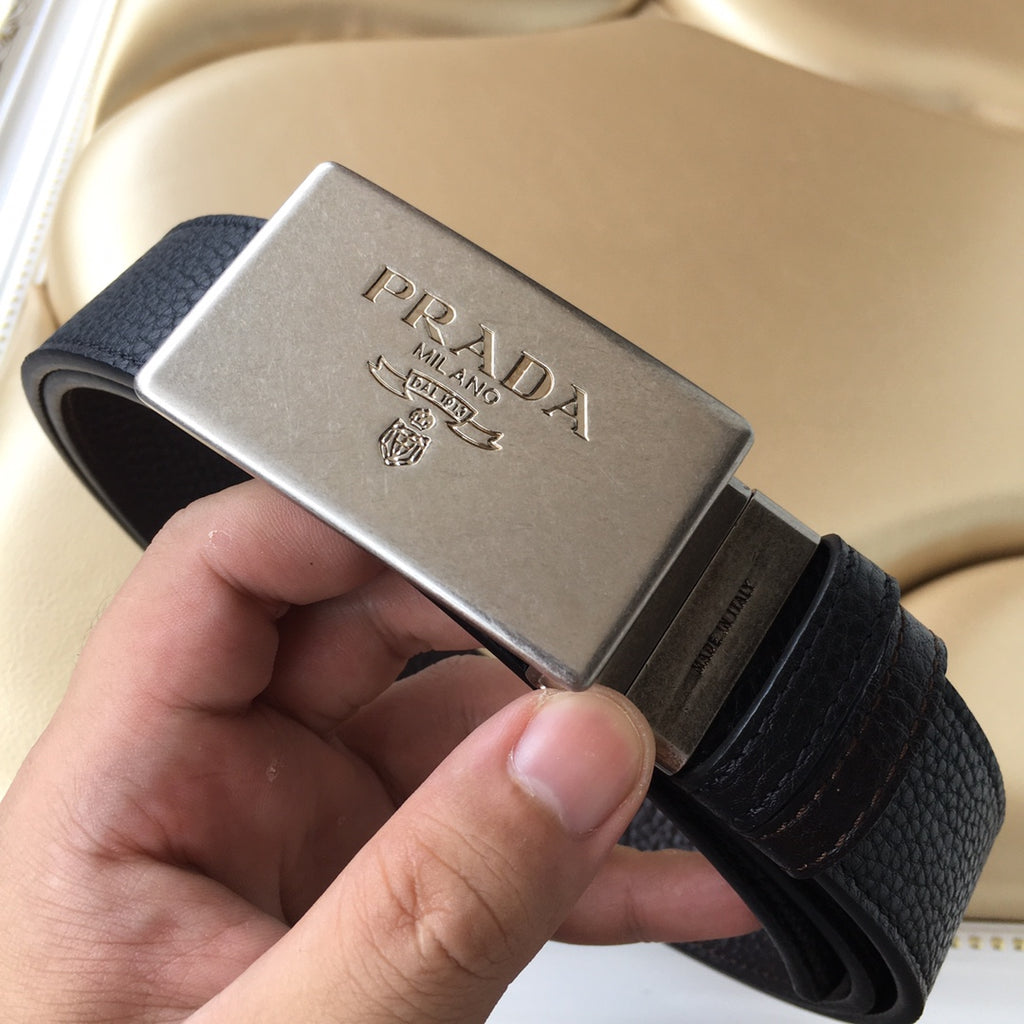 Prada belt with dark leather strap and square silver buckle in hand
