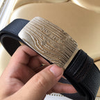 Prada belt close-up: silver logo buckle with dark leather strap and keeper loop