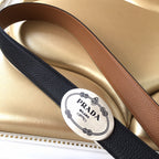 Leather belt with logo patch, black and tan/brown strap pair, laid on surface