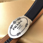Leather belt end with Prada Milano logo patch, dark strap over brown section