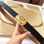 Prada belt with textured dark blue strap and gold oval logo buckle.