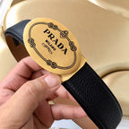 Prada belt close-up: gold logo buckle on dark blue textured strap.