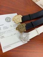 Two belts with textured straps and gold-toned emblem buckles