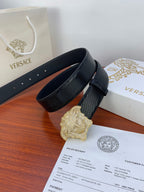 Black textured belt with gold emblem buckle and matching dark strap