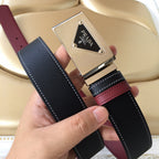 Prada belt buckle close-up: silver frame on black strap with burgundy center stripe.