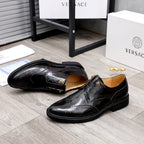 Versace black oxford shoes with wingtip detailing and gold-tone buckle