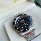 Rolex Submariner watch with black dial, blue-tinted accents, stainless steel bracelet