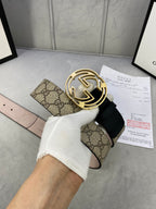 Gucci belt with tan GG monogram canvas and black leather strap with gold-tone interlocking G buckle.