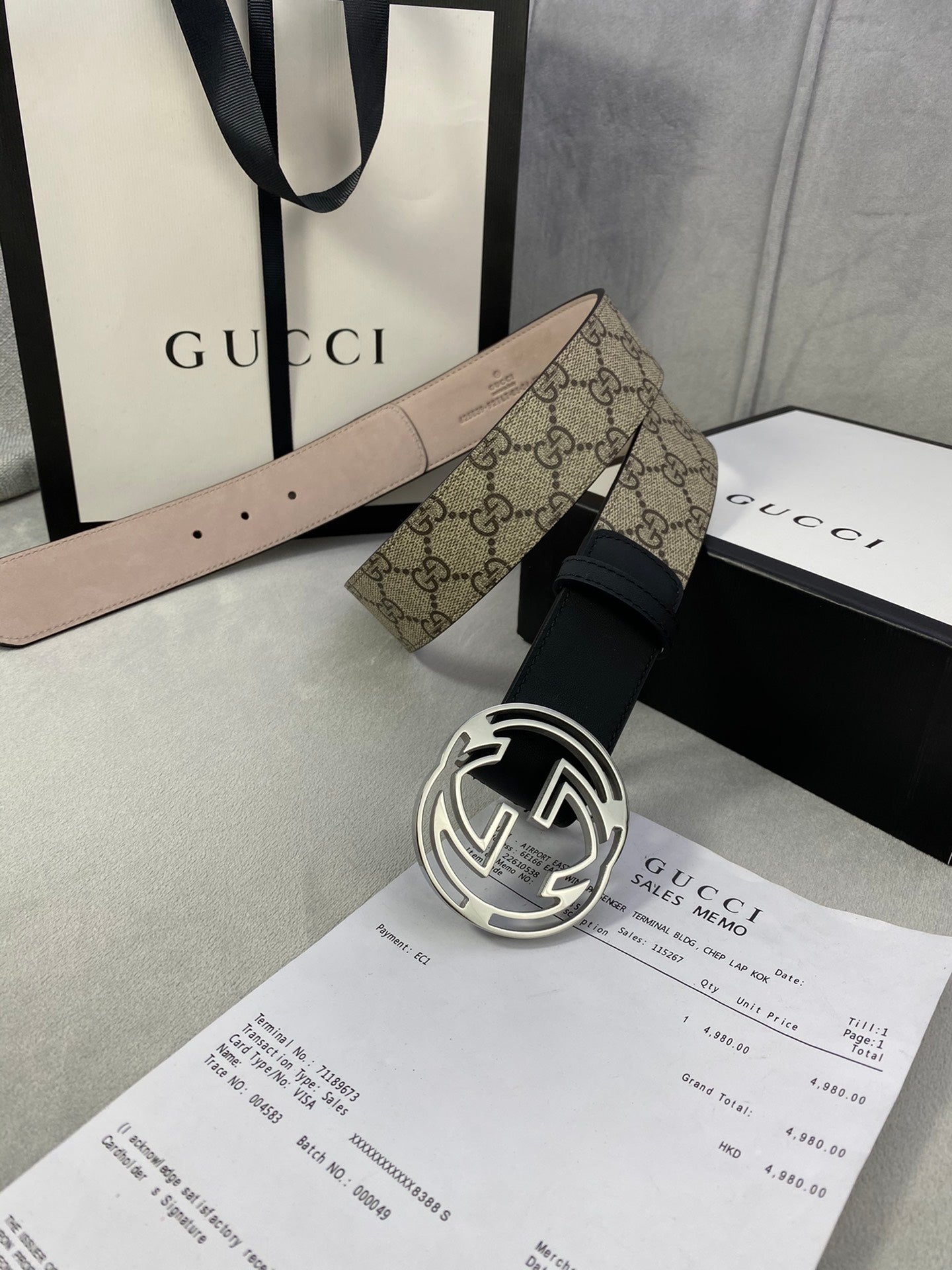 Gucci belt with tan GG monogram canvas strap, black leather belt, and silver-tone interlocking G buckle.