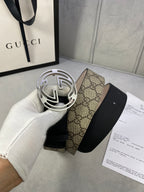 Gucci belt with silver-tone interlocking G buckle and GG monogram canvas section on black strap.