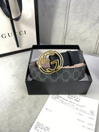 Black GG monogram belt with gold-toned interlocking logo buckle, laid across a box.