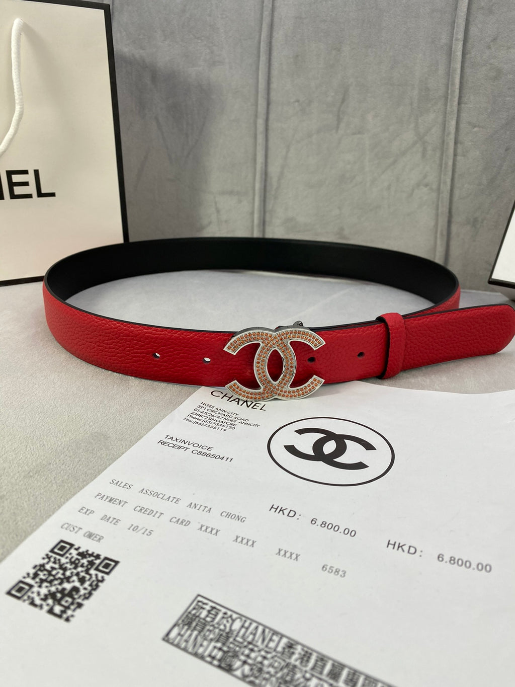 Red leather belt with gold CC-style buckle and black backing strap