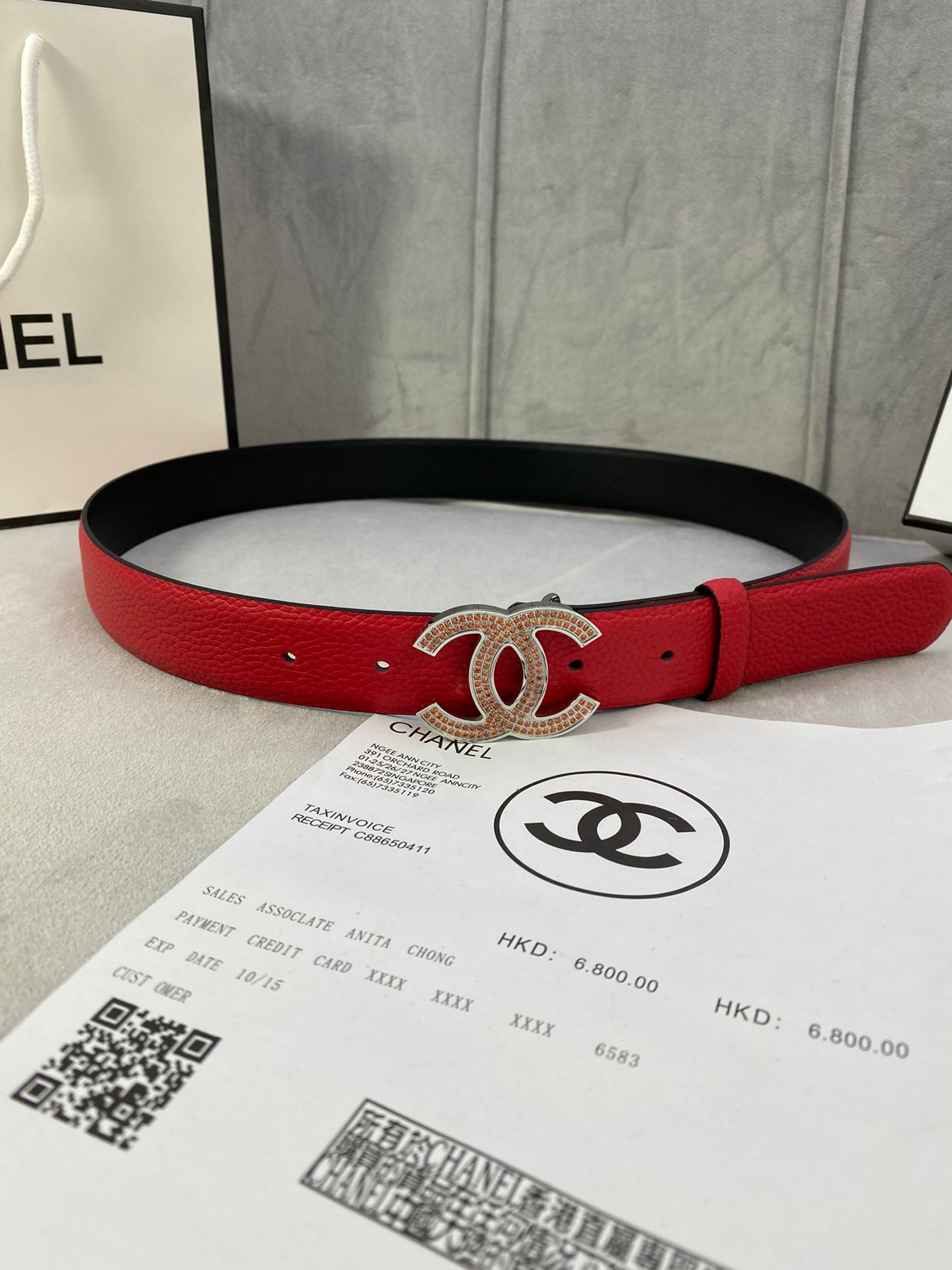 Red leather belt with gold CC-style buckle and black backing strap