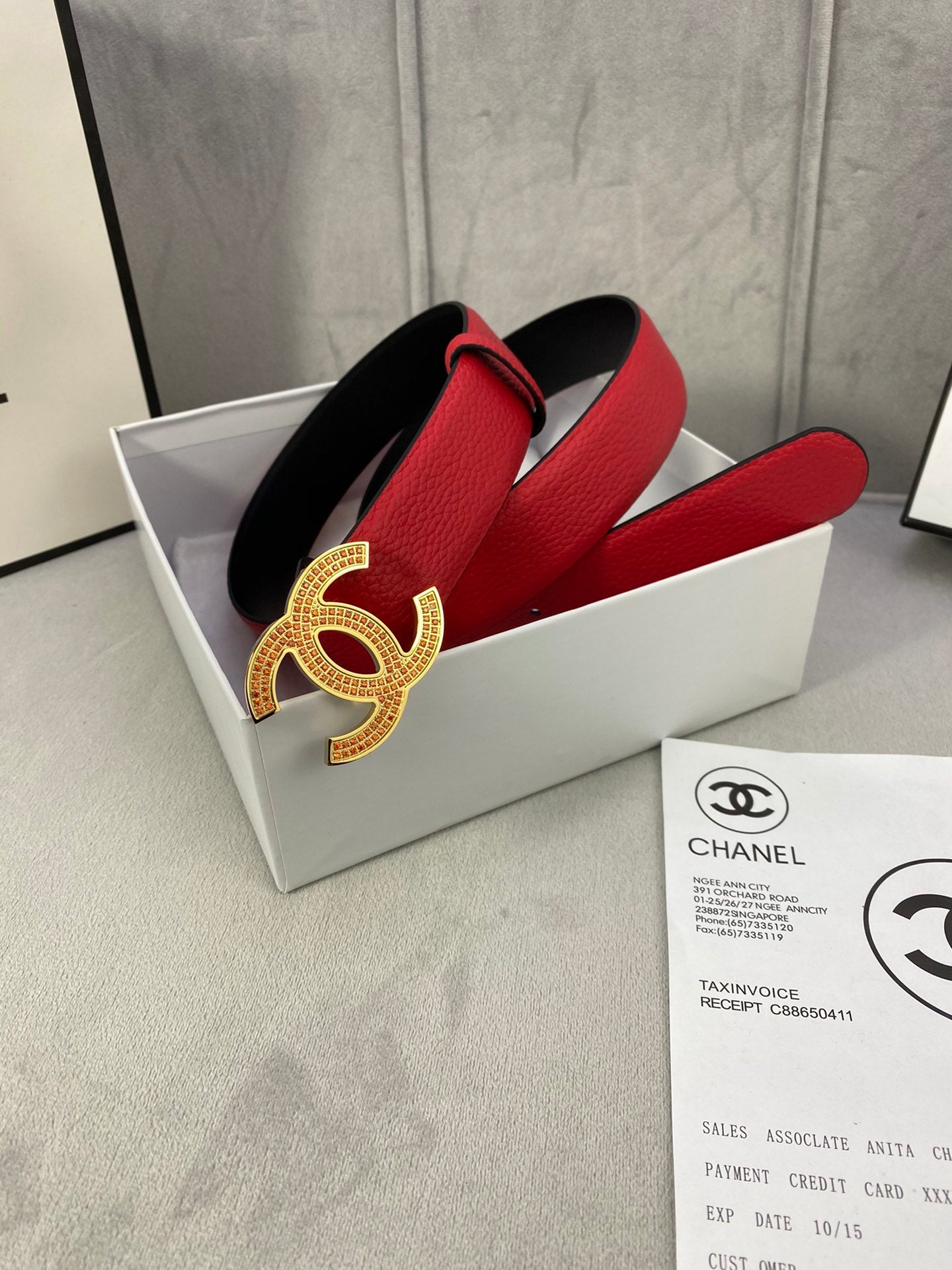 Red leather belt with gold CC-style buckle and wide adjustable strap
