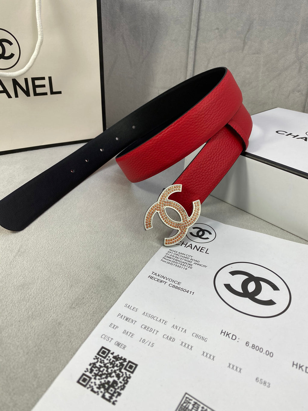 Red leather belt with gold CC-style buckle and black inner strap