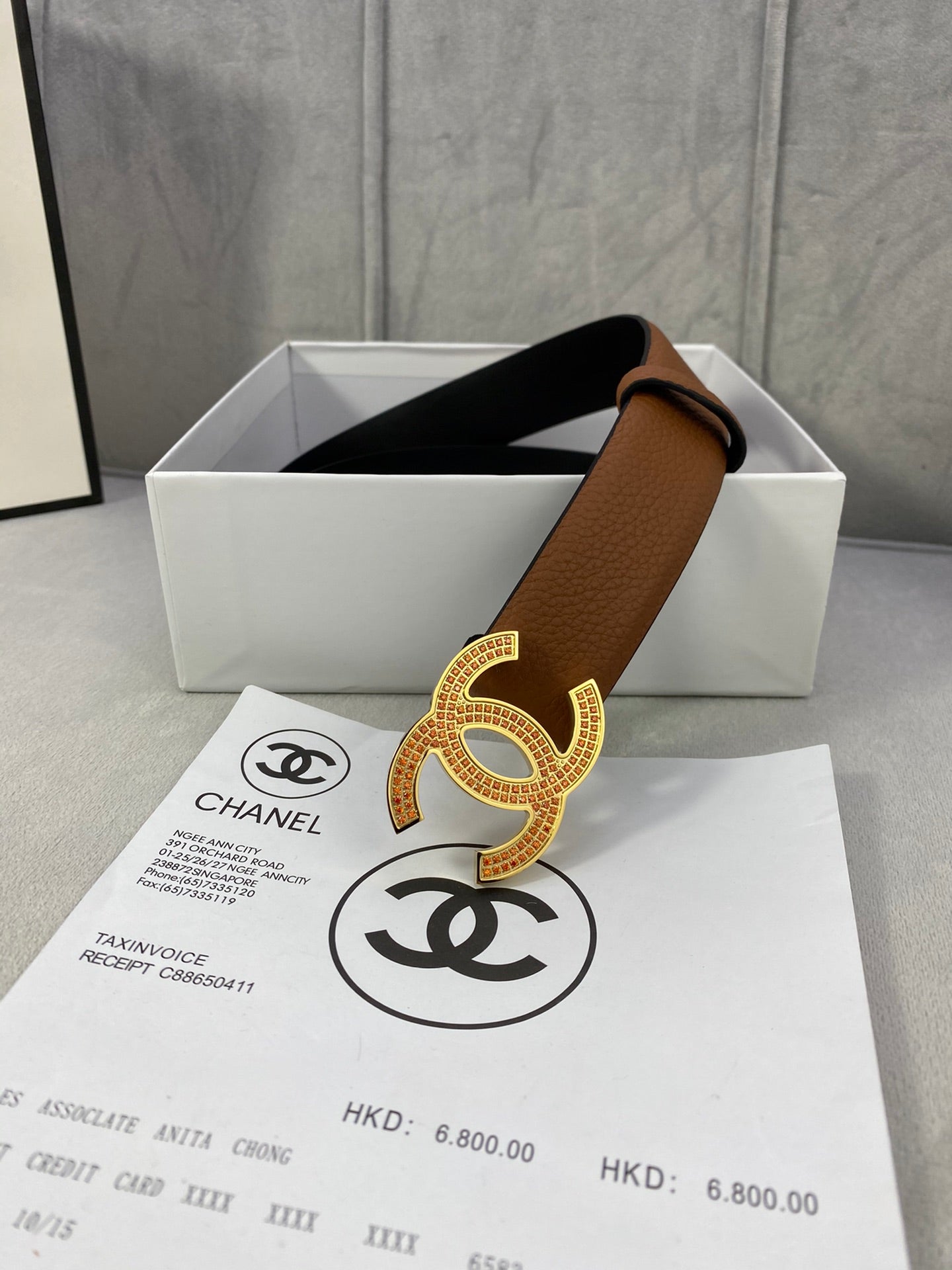 Brown leather belt with gold CC buckle on the front and dark underside visible