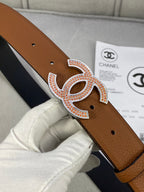 Brown leather belt with gold CC buckle and rhinestone trim, dark underside visible