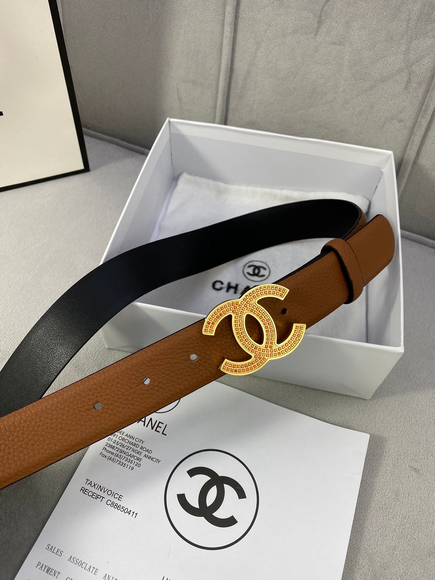 Brown leather belt with gold-toned CC buckle and dark inner strap