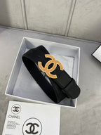 Black leather belt with gold CC logo buckle, packaged in a gift box with strap end.